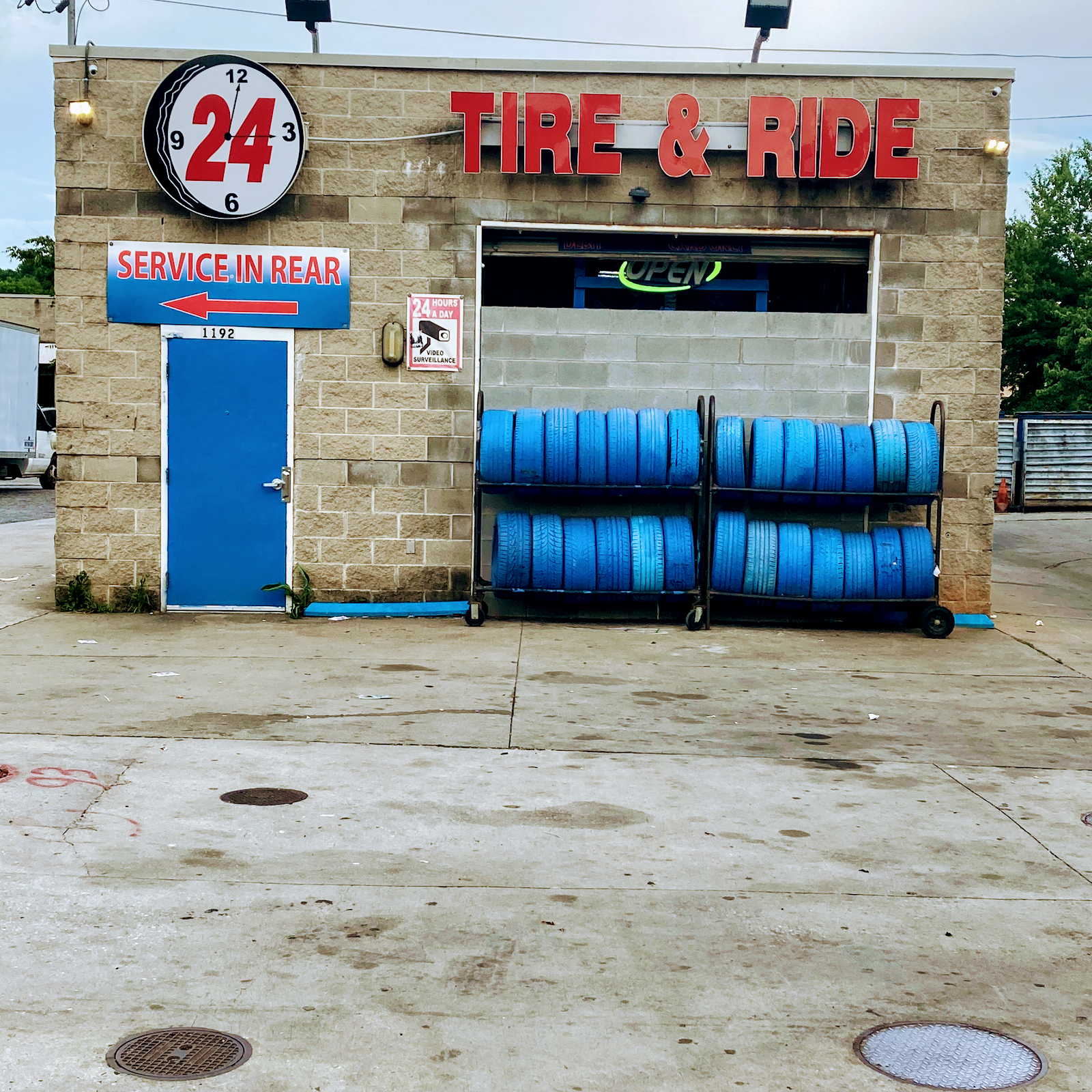 Tire & Ride Mobile — Atlanta shop front with 24 TIRE and RIDE sign and blue-wrapped tire inventory racks